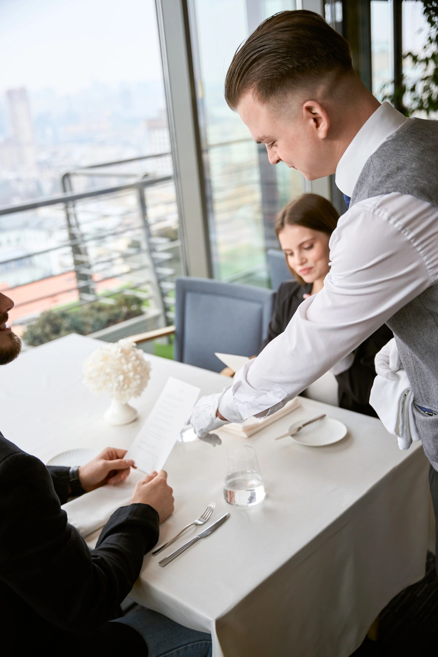 Waiter assisting guests during a restaurant dining experience