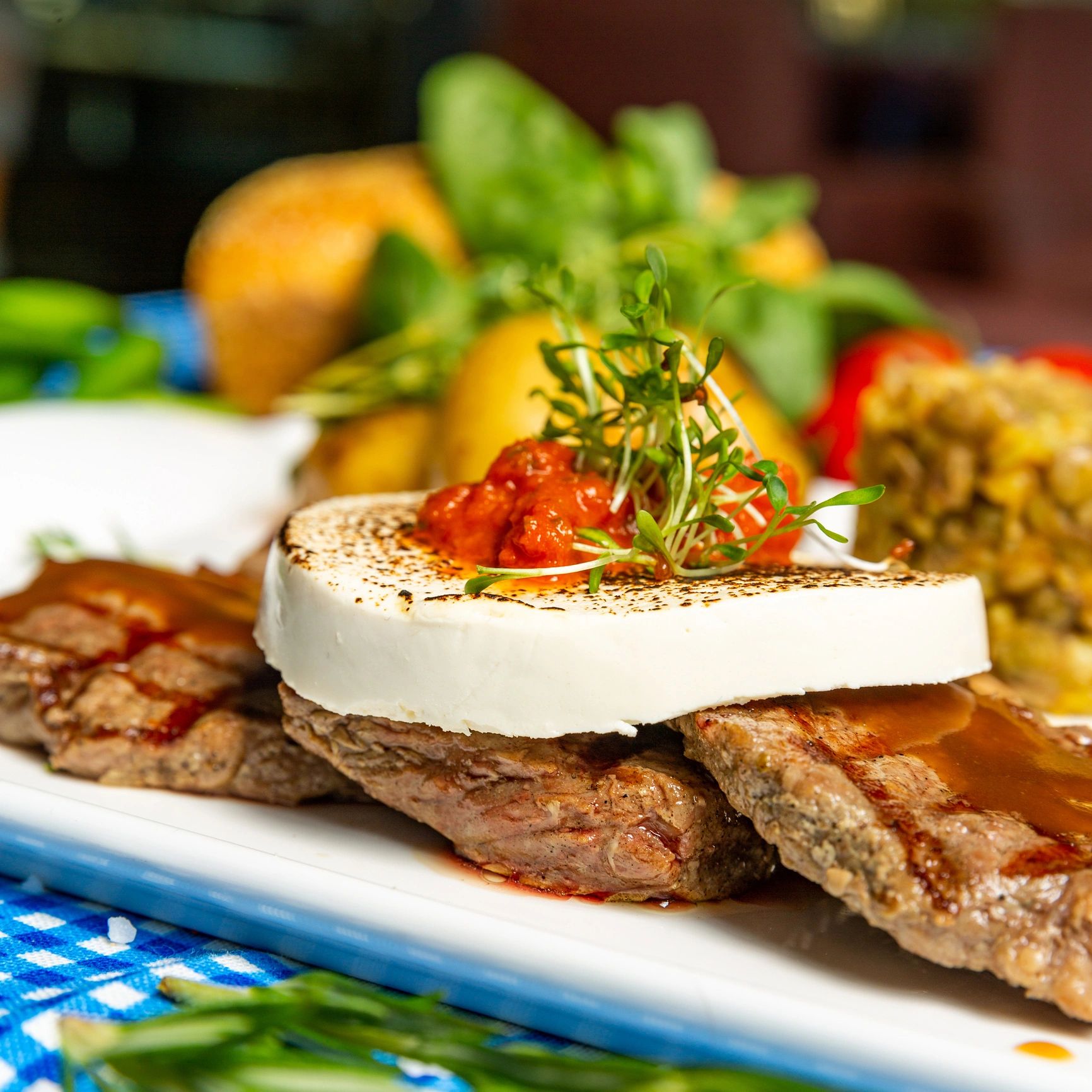 Plated steak with microgreens and goat cheese